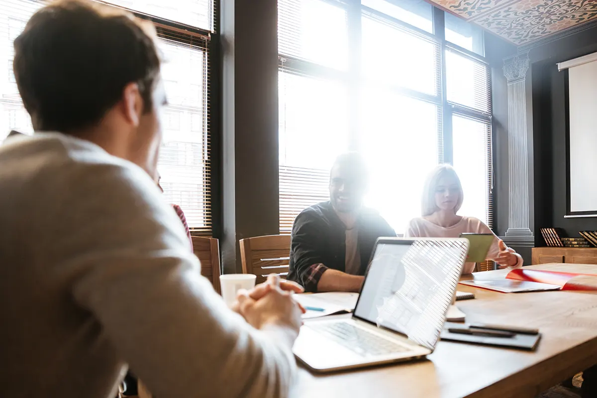 jóvenes en una oficina sentados a la mesa trabajando juntos
